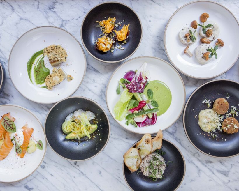 Various dishes in white and black bowls on a marble table