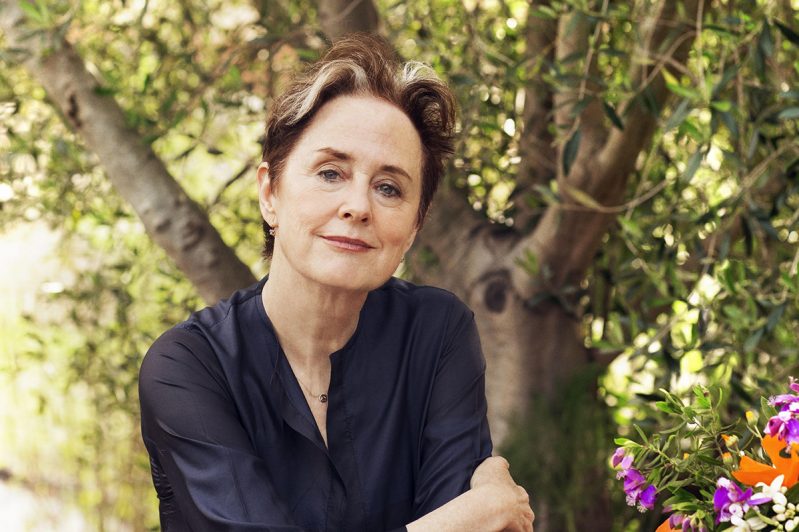 Alice Waters smiling in front of a tree