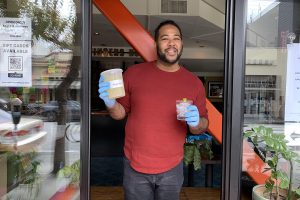 A man holds a quart container filled with margaritas