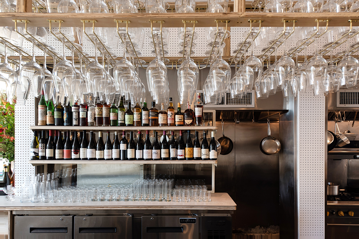 A bar with wine glasses stacked above it