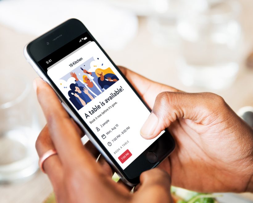 A person uses OpenTable's Availability Alerts on their phone