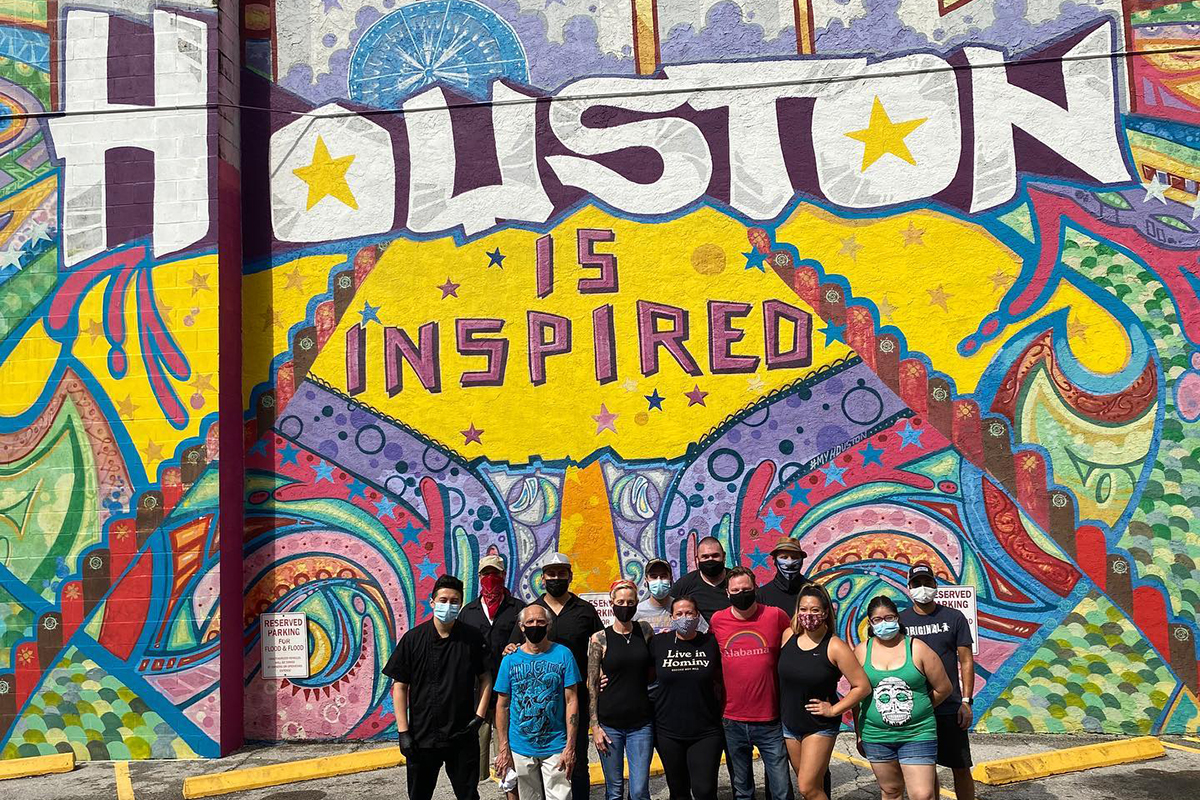 Houston restaurant workers take a photo in front of a 