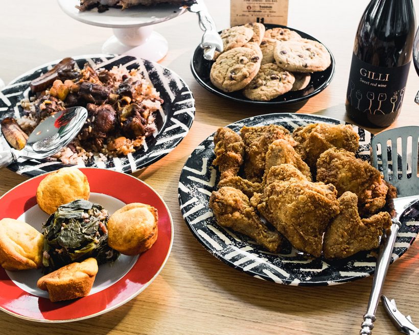 A spread of food including fried chicken, chocolate chip cookies, and red wine