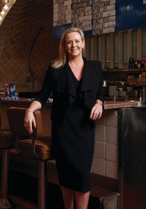 Clare Reichenbach leans against a bar