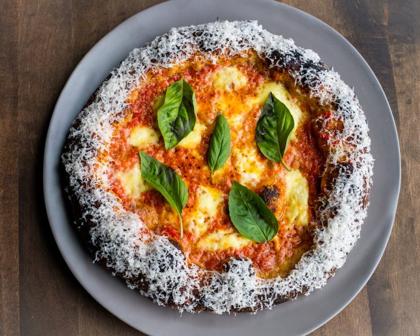 A margarita pizza on a grey plate