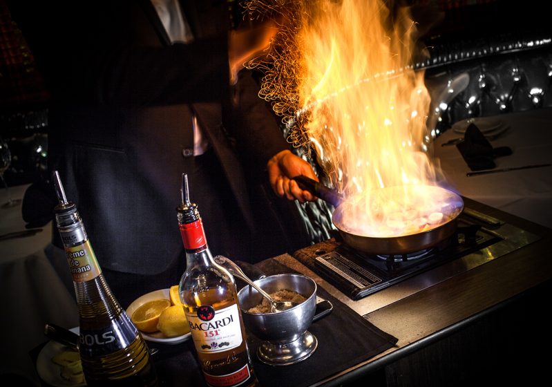 A server doing tableside flambe