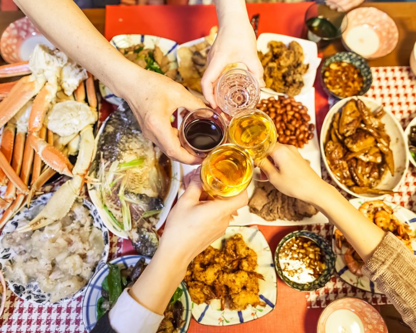 People toasting over a table laden with Lunar New Year dishes
