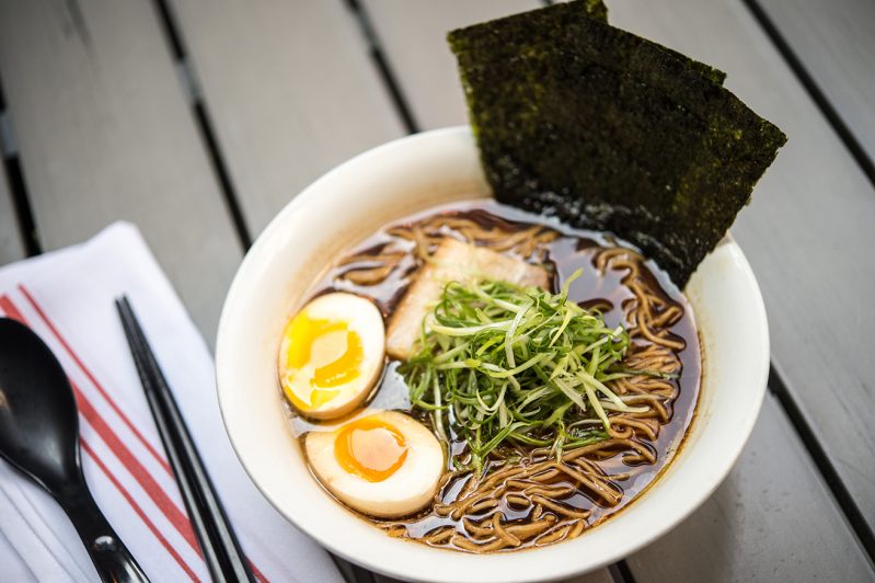 A bowl of ramen sits on a table.