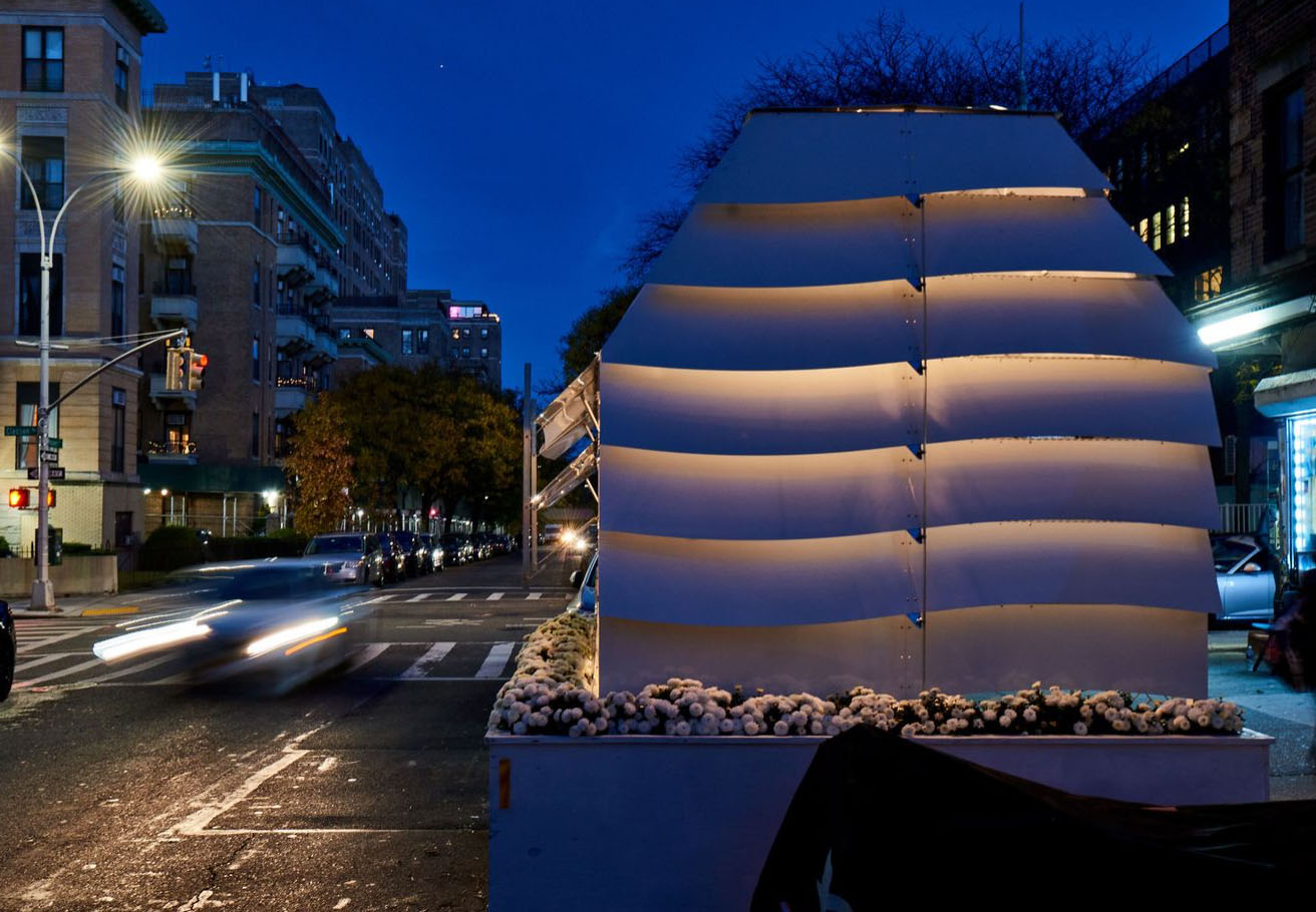 An outdoor dining structure on a street at night.