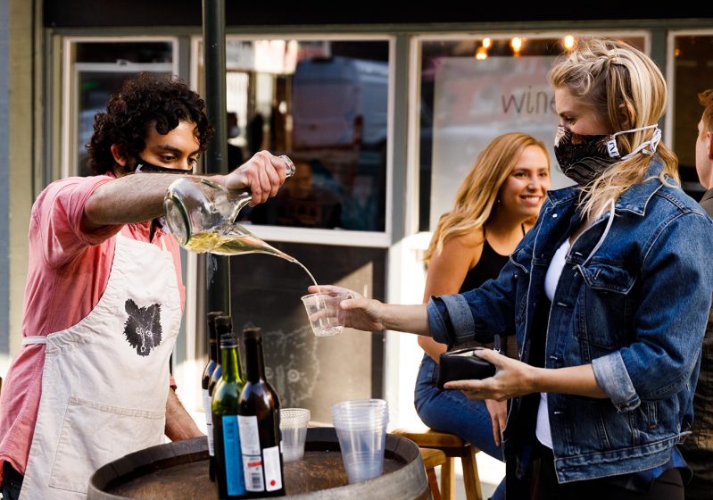 Daniel Azarkman pours wine out of a porron