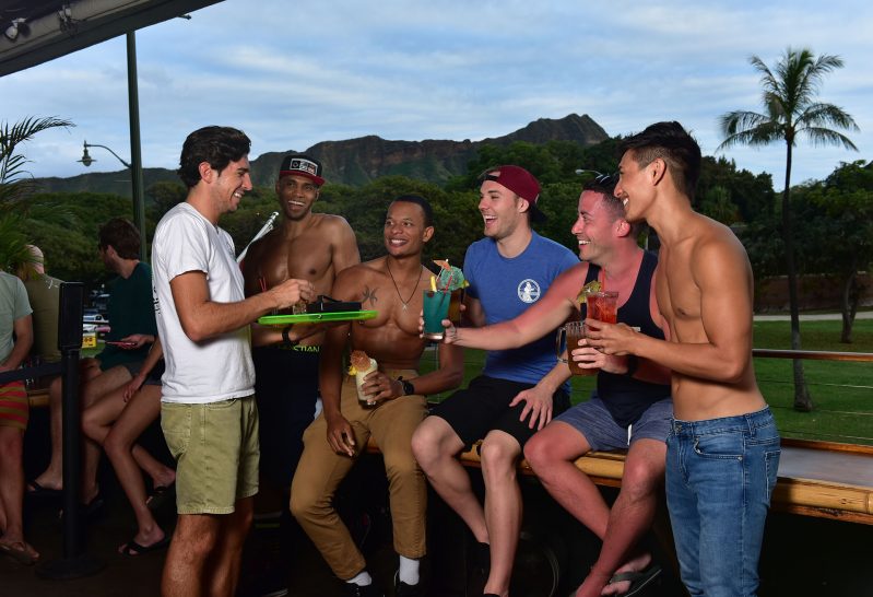 A server hands out drinks to a group of men.