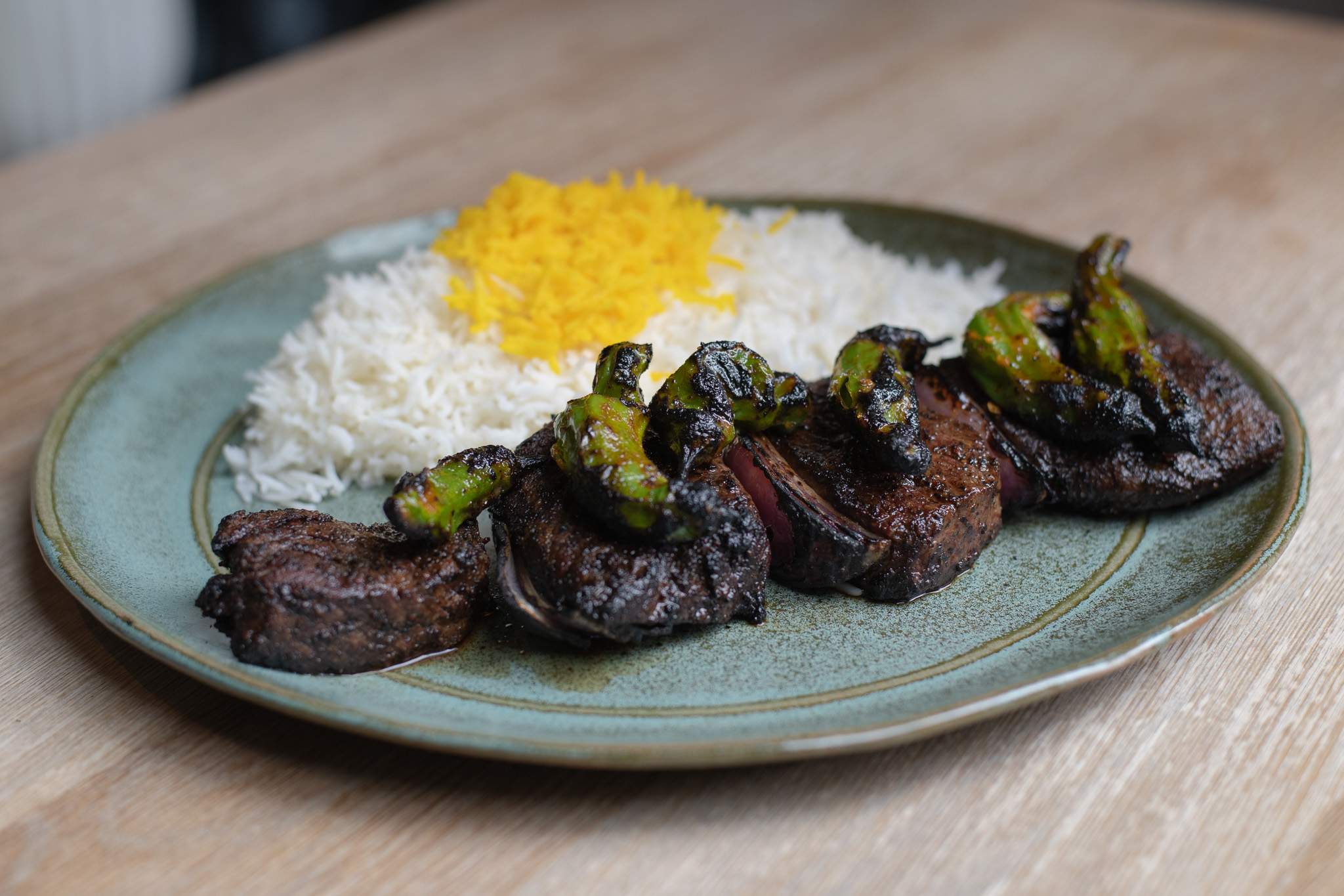 An American wagyu kabob at Rumi’s Kitchen in Houston with Urfa chile spice rub, grilled shishito peppers, red onion, and saffron basmati rice