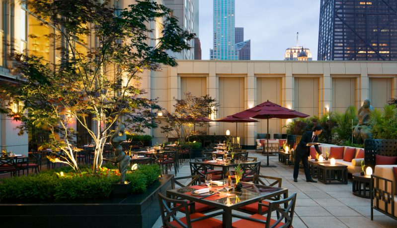 Maroon umbrellas line the outdoor dining area at Shanghai Terrace in Chicago.