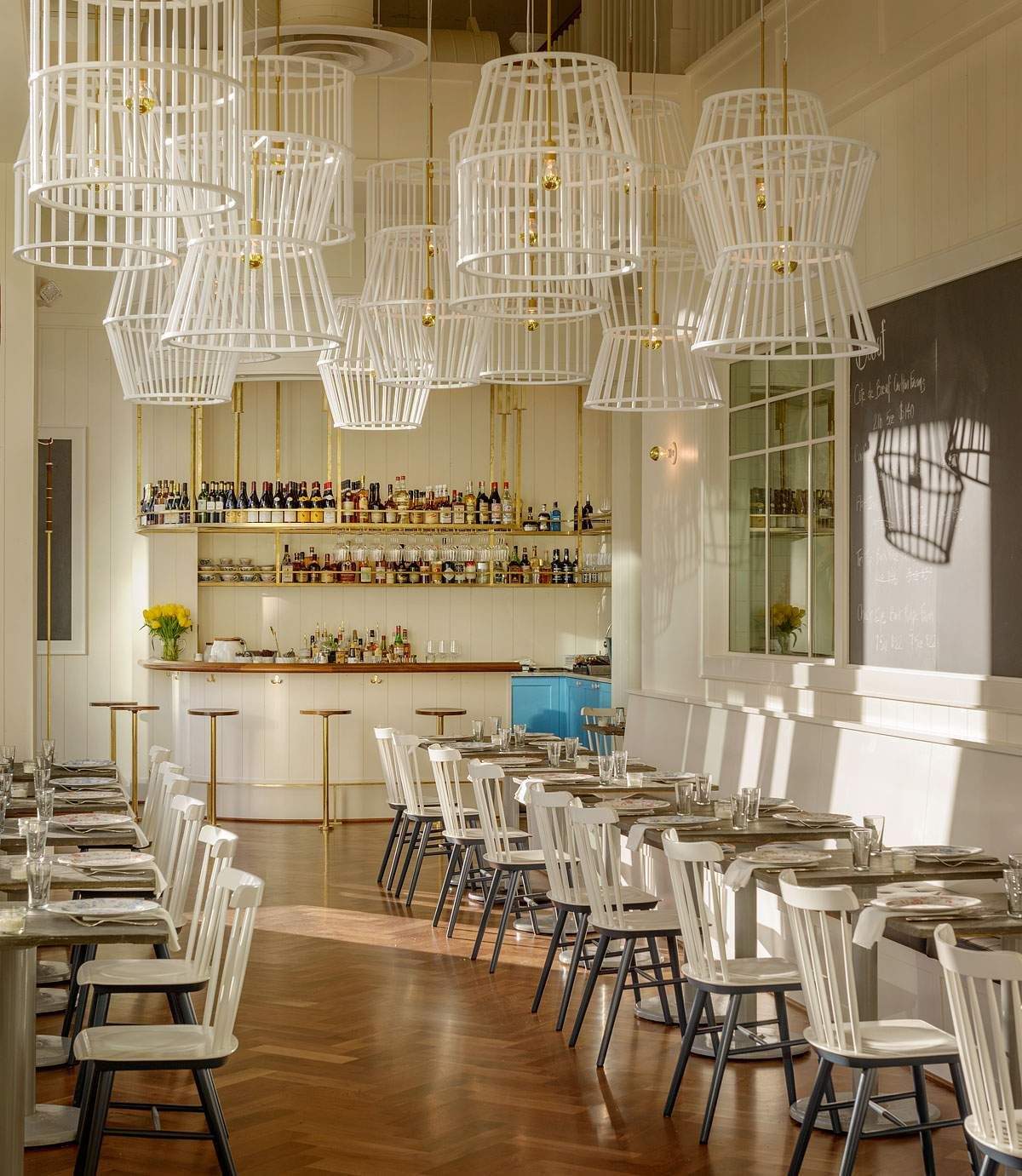 White caged pendant lights hang from the ceiling at Bateau