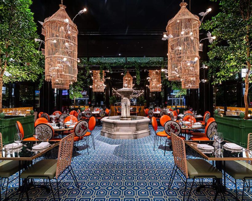 A 19th-century limestone fountain, hanging bird cages, and blue-tiled floors at ilili - DC