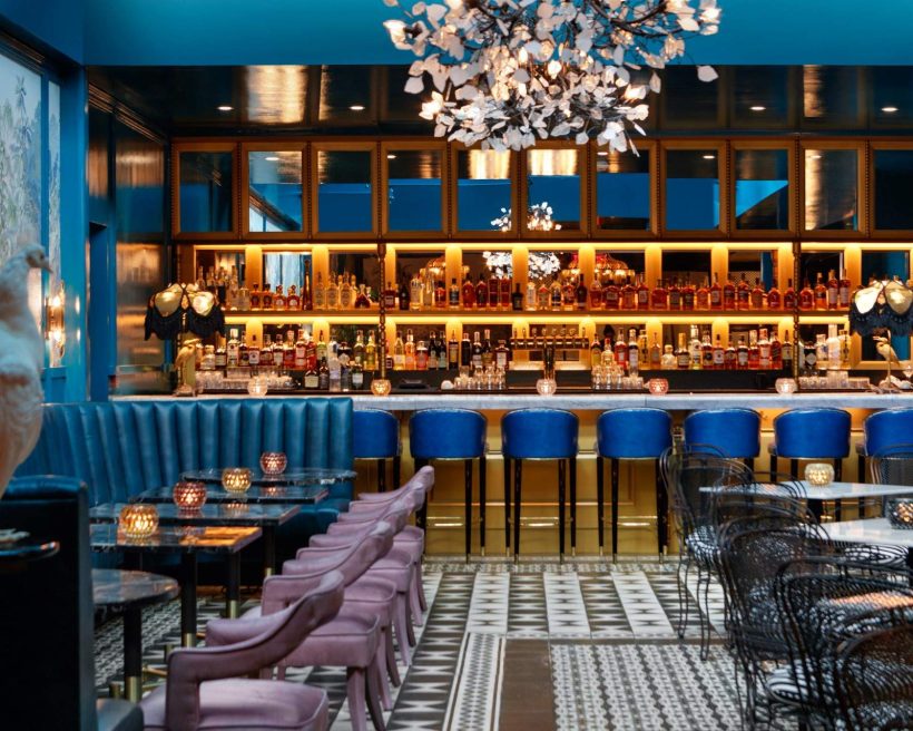 Rich velvets, rolled leather banquettes, and a collection of gilded cages and feathered birds at the Peacock Lounge at the Kimpton Hotel Fontenot