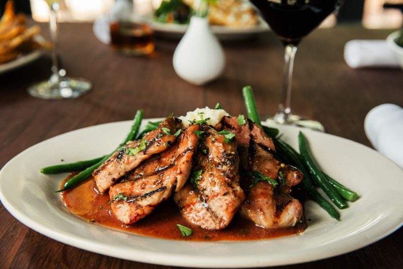 Marinated pork tenderloin with savory plum sauce, mashed potatoes, and haricots verts at Germantown Cafe.