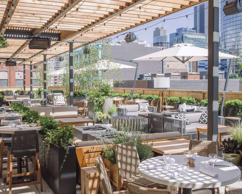 A plant-lined pergola makes up outdoor dining area at Aba in Chicago