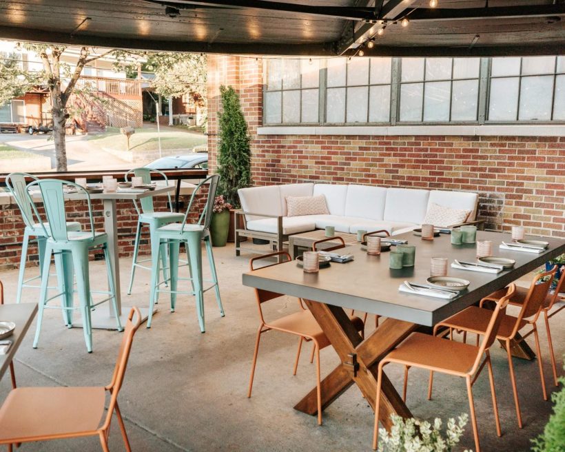 The brick-lined circular patio at Sadie’s in Nashville is complete with various seating options including couch-style seats and high-top tables.