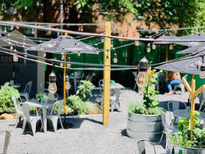 Bistro lights and a neon green picket fence make up the outdoor dining space at Jet Wine Garden in Philadelphia.