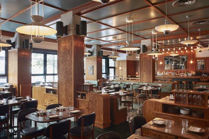 Pendant lights and wooden dining tables at As You You Are, a bar, cafe, and restaurant in Brooklyn