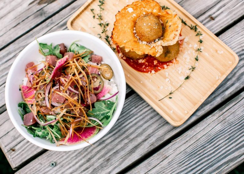 A poke bowl with jalapeño-marinated tuna over rice, greens, watermelon radish, fried leeks, and red onion at Backyard Restaurant in the Hamptons
