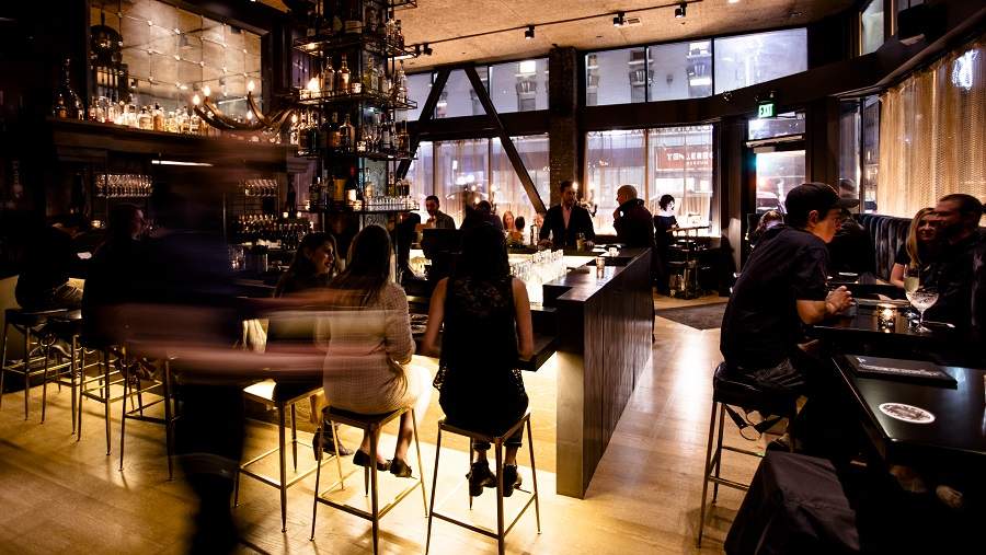 People sit around the horseshoe-shaped bar at Black Cat Jazz Supper Club in San Francisco