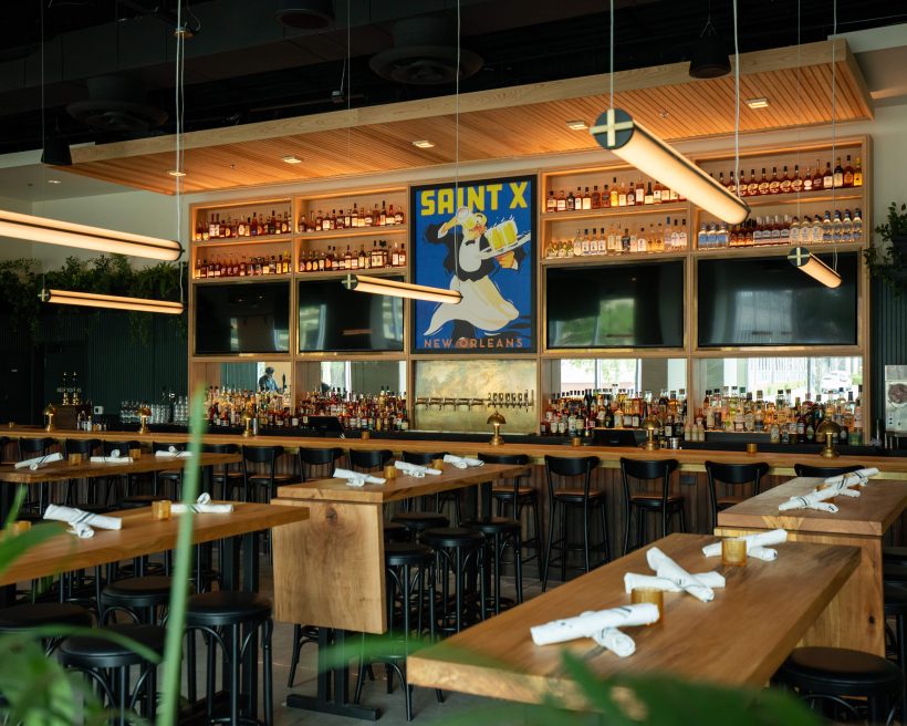 A series of wooden countertop seats at Brewery Saint X in New Orleans