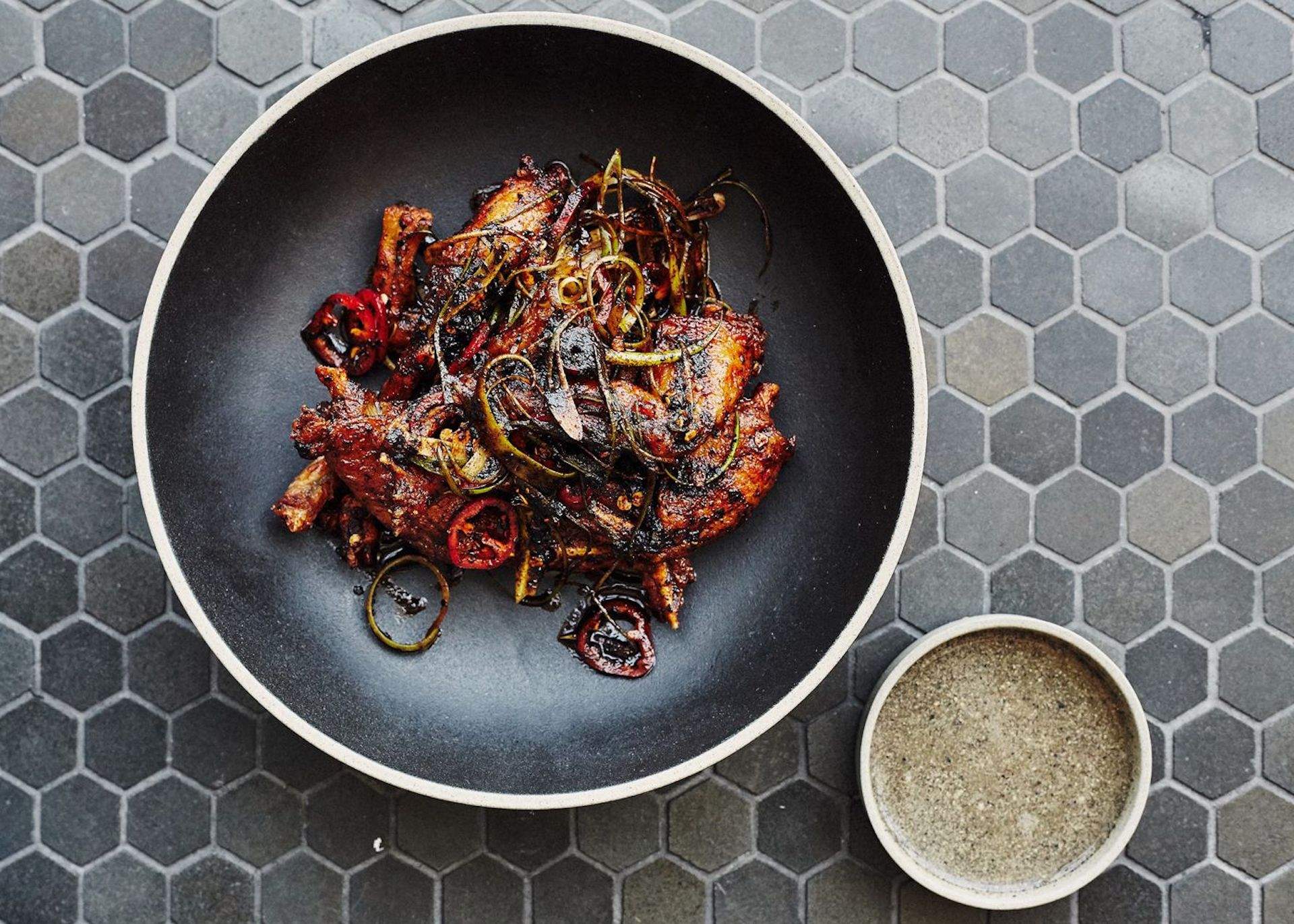 A dish of frog legs placed in a black plate