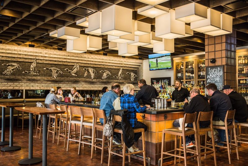 People dine and drink at the horseshoe-shaped bar at Meril in New Orleans.