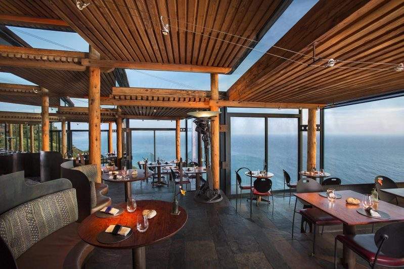 Floor-to-ceiling windows and Pacific Ocean views at Sierra Mar – Post Ranch Inn in California.