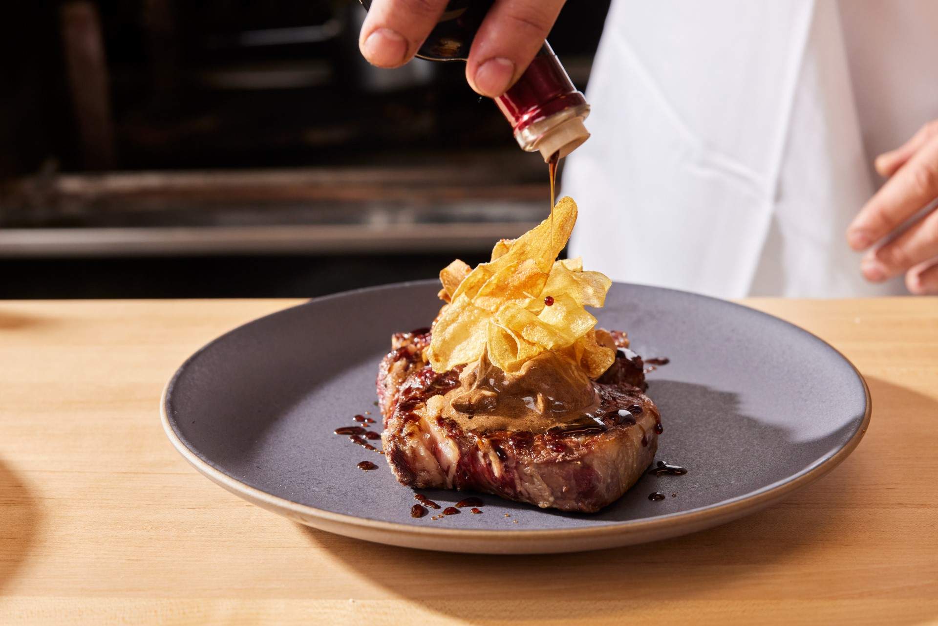 Ribeye steak with bintje potatoes and black garlic butter at Acre in Oakland