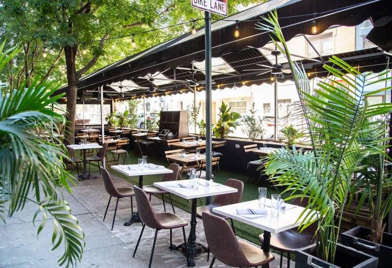Casa Ora’s covered streetfront terrace channels a tropical getaway. | Credit: Casa Ora