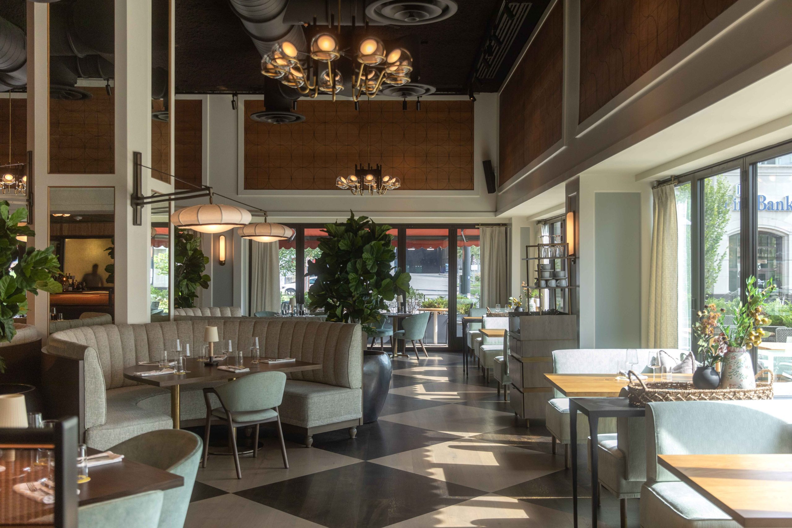Upholstered banquettes, light oak wood paneling, and cantilevered lighting at Evelyn’s in Nashville