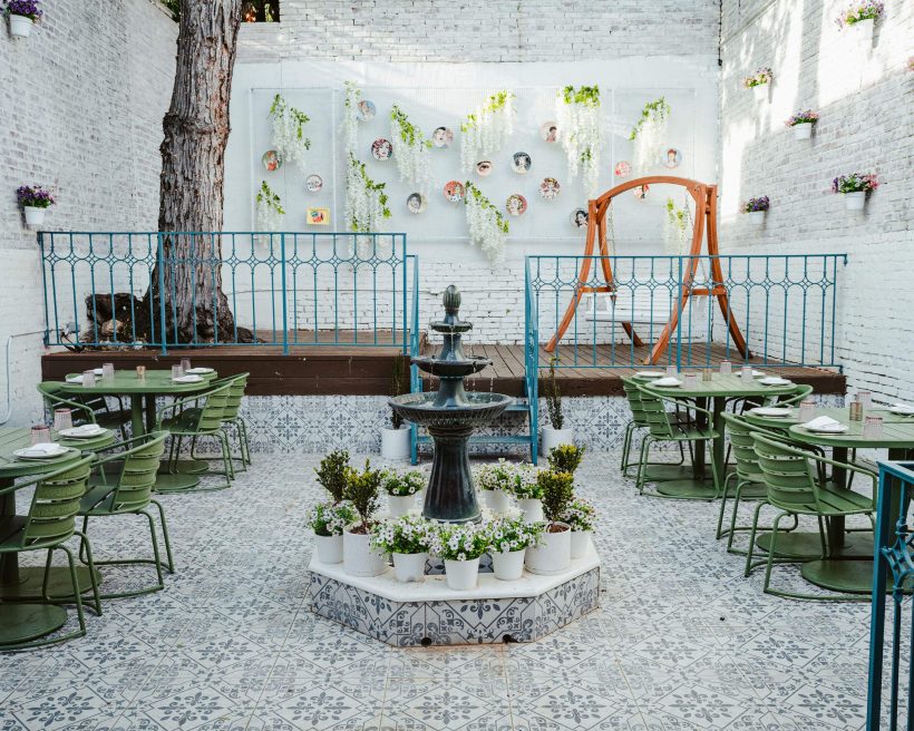 A courtyard fountain is wreathed by potted plants at Villa Yara in Washington, DC.