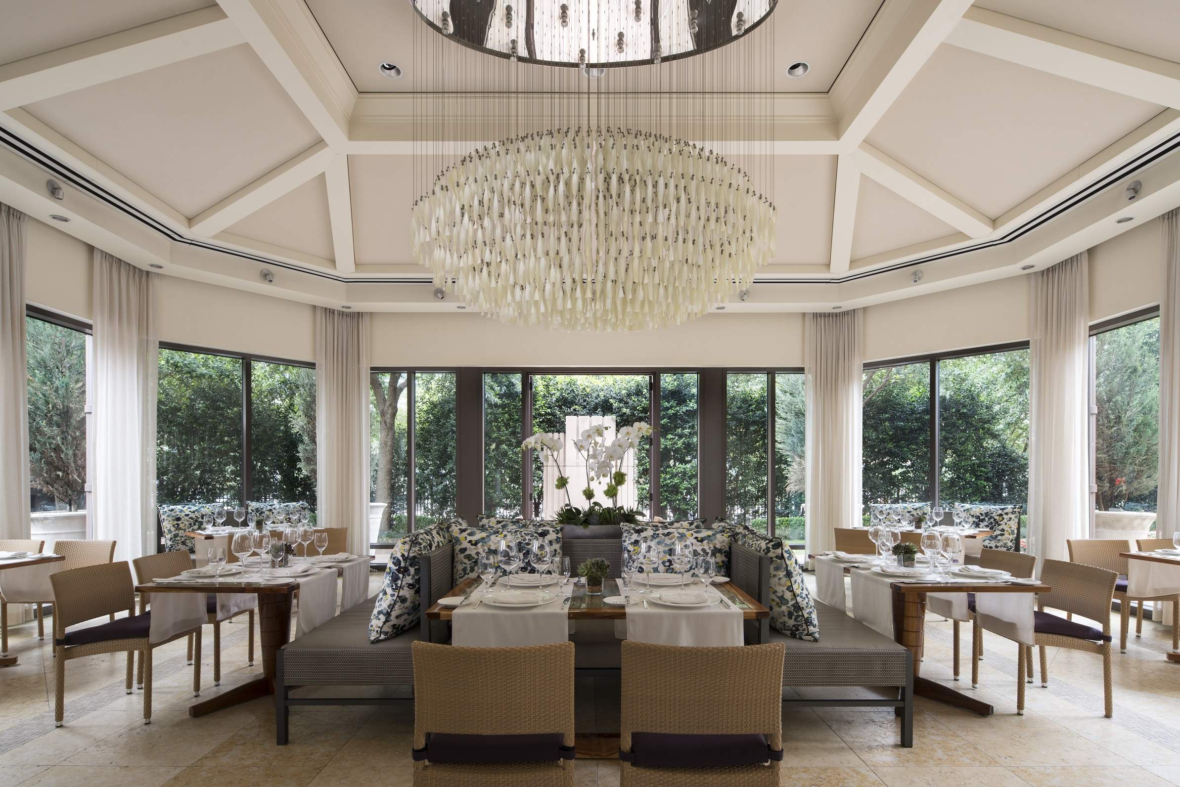 A tasseled white sculpture hangs from a ceiling mirror at Fearing’s in Dallas
