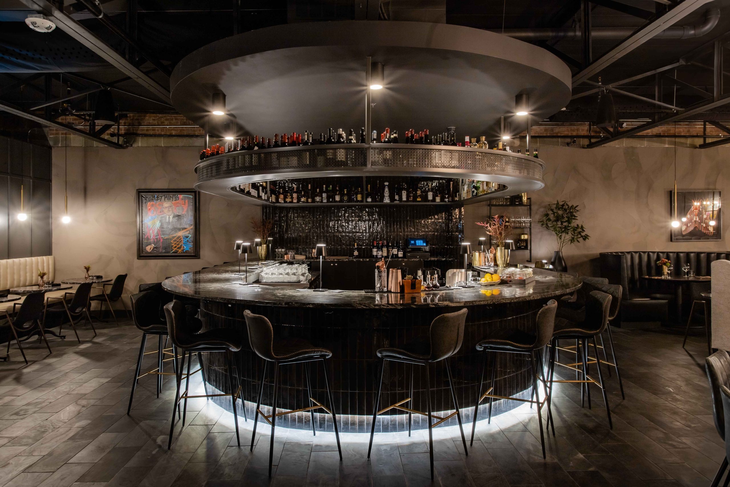A striking oval-shaped bar and leather and velvet accents make up the interiors at The Saint in Dallas