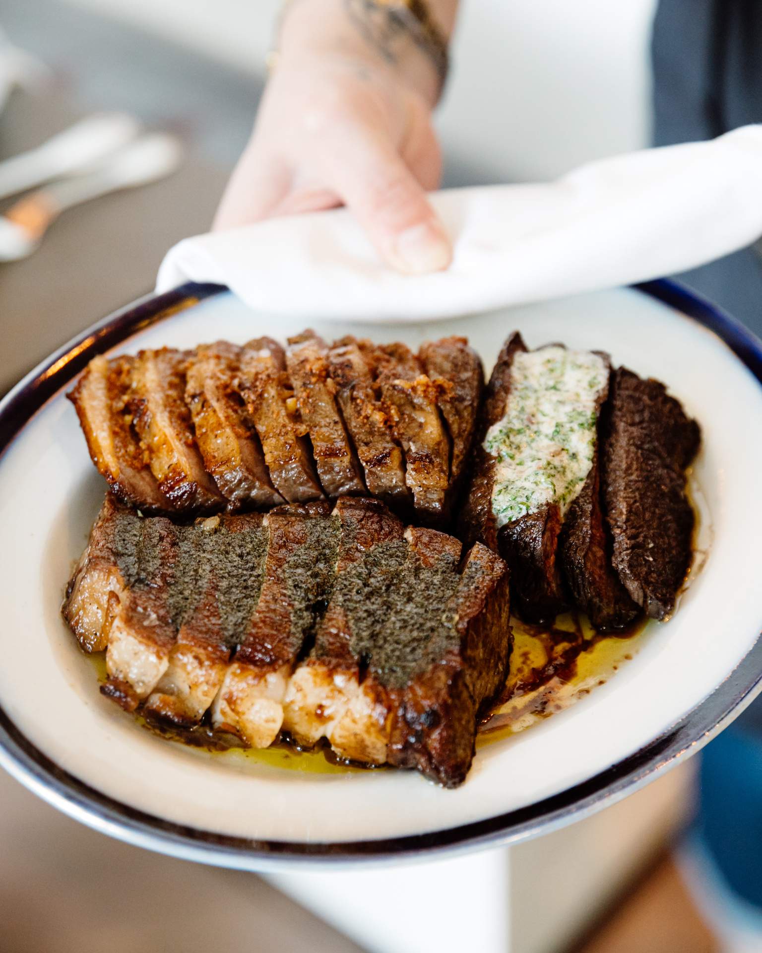 Cut up porterhouse steak on a white plate from Bateau in Seattle