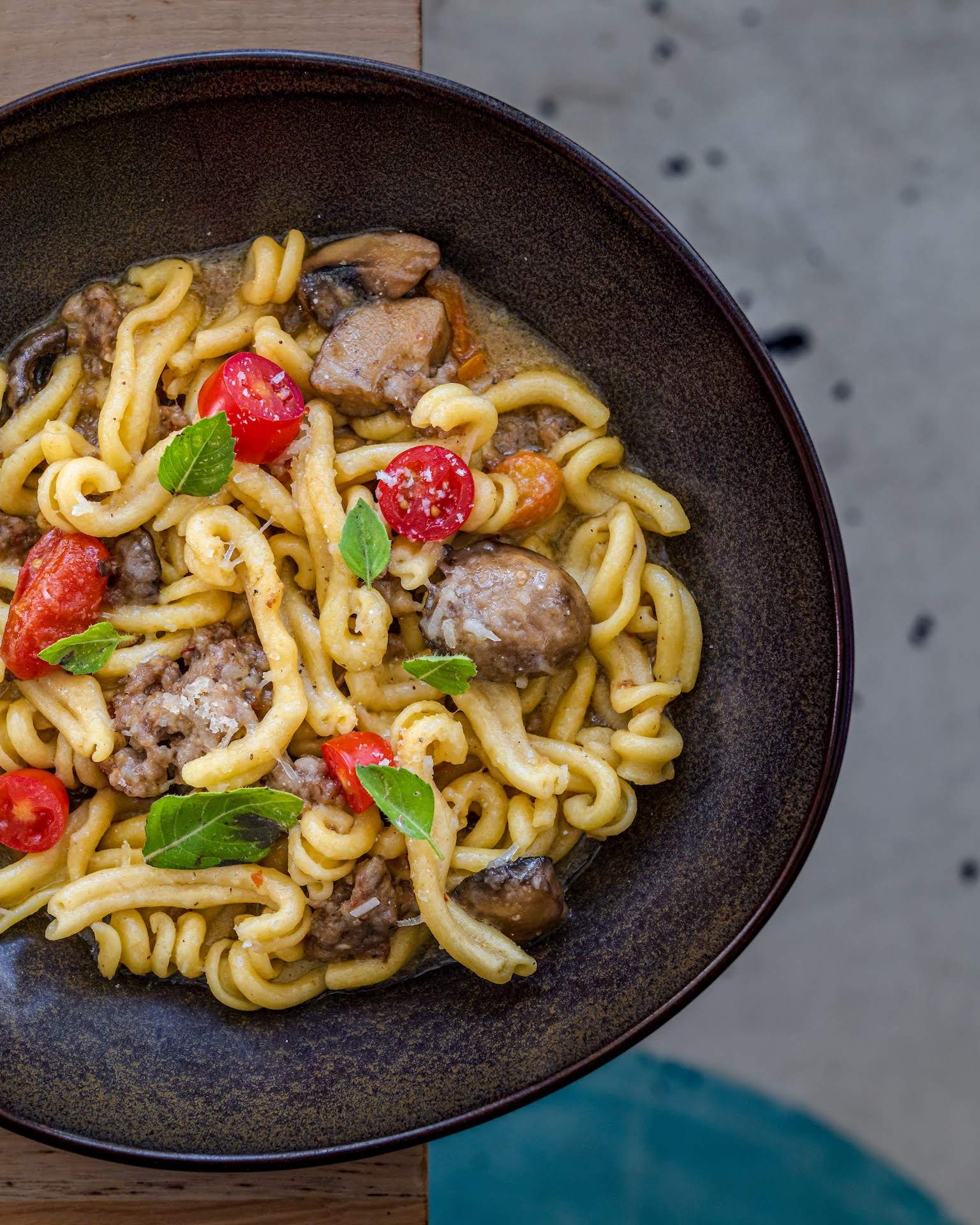 Casarecce with housemade garlic sausage, chestnut mushroom conserva, and cherry tomatoes at L’Oca D’Oro.