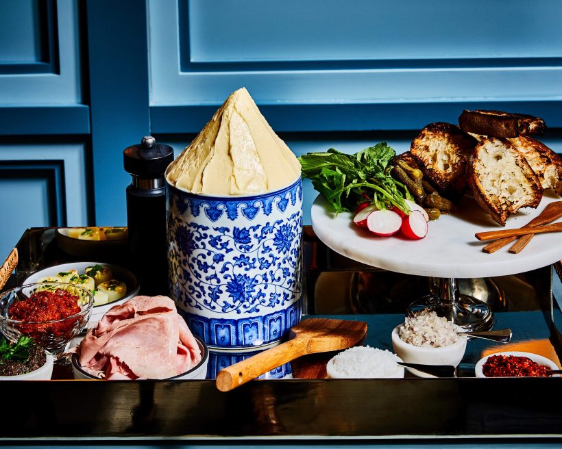 A butter board at Quality Bistro, paired with crusty bread, cornichons, French ham, and leek vinaigrette.