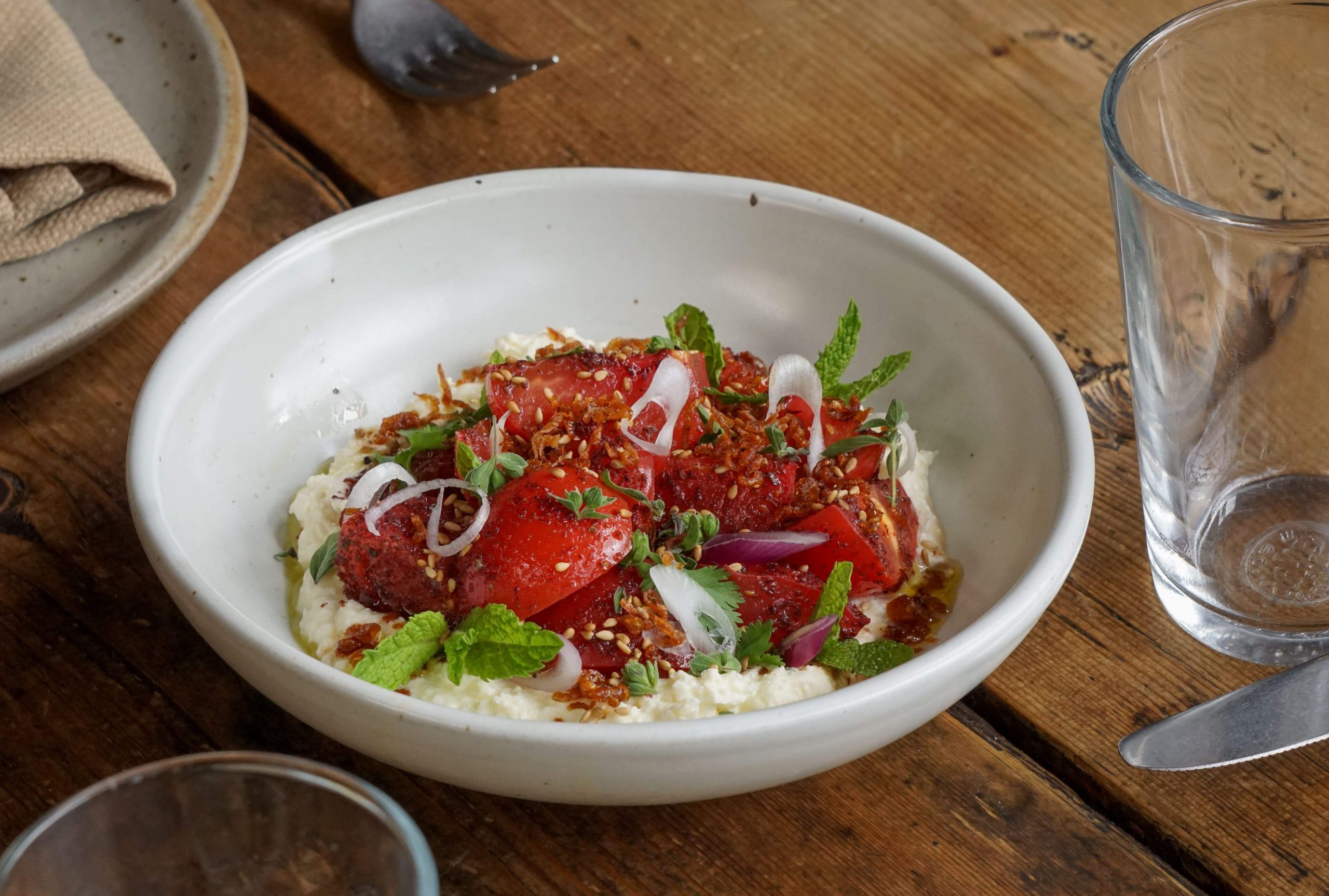Tomato salad with whipped feta, sumac vinaigrette, lime, oregano, and crisp shallot at Manuela in Los Angeles