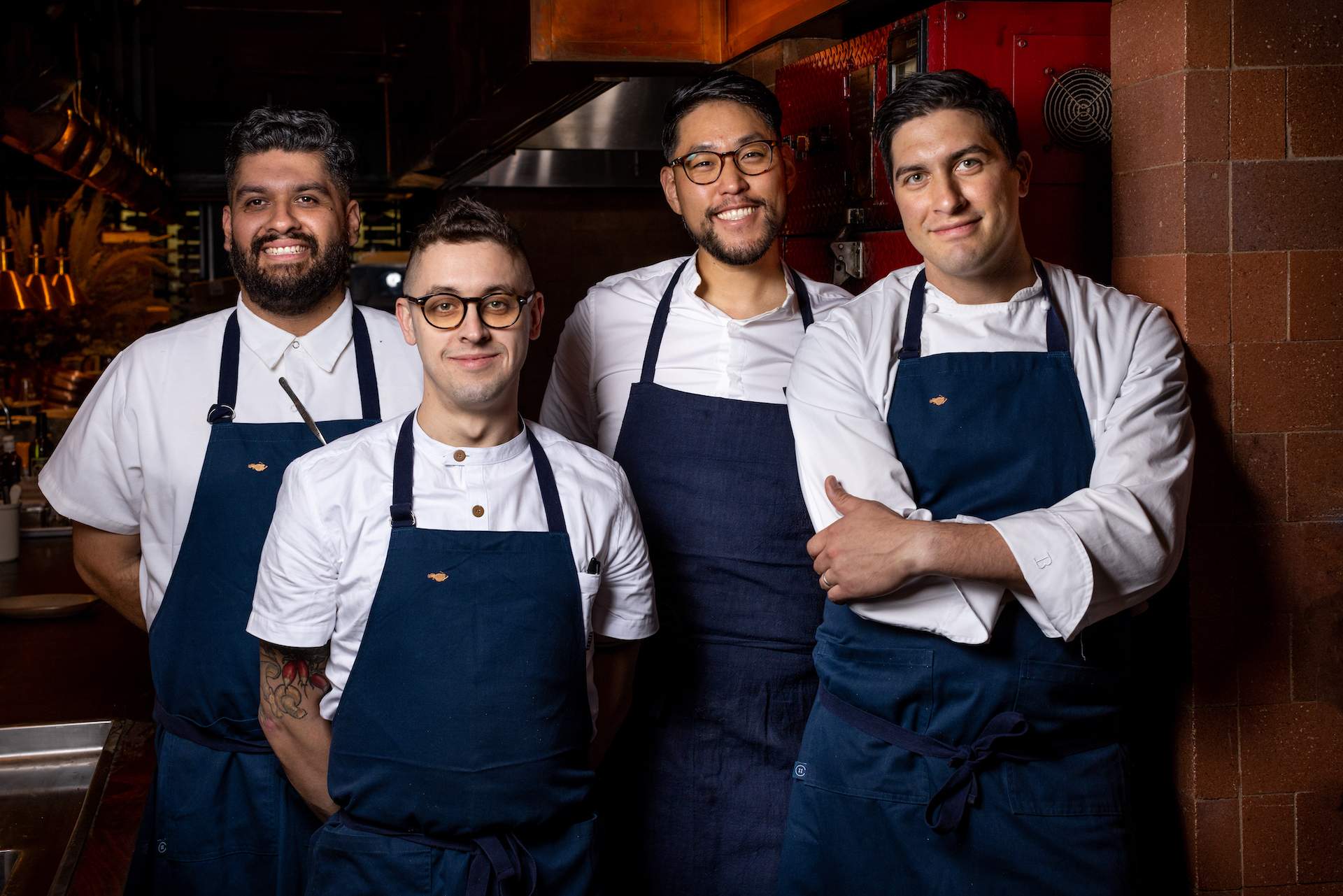 The Angler LA team. Seen here are four men wearing white shirts and blue aprons.