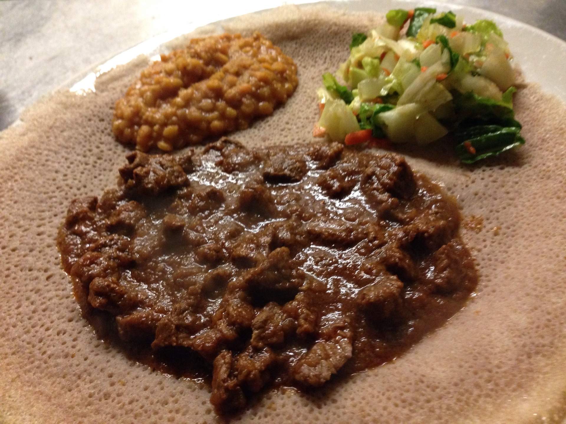 Ethiopian injera bread with a lentil and meat stew topping at NYC restaurant Massawa