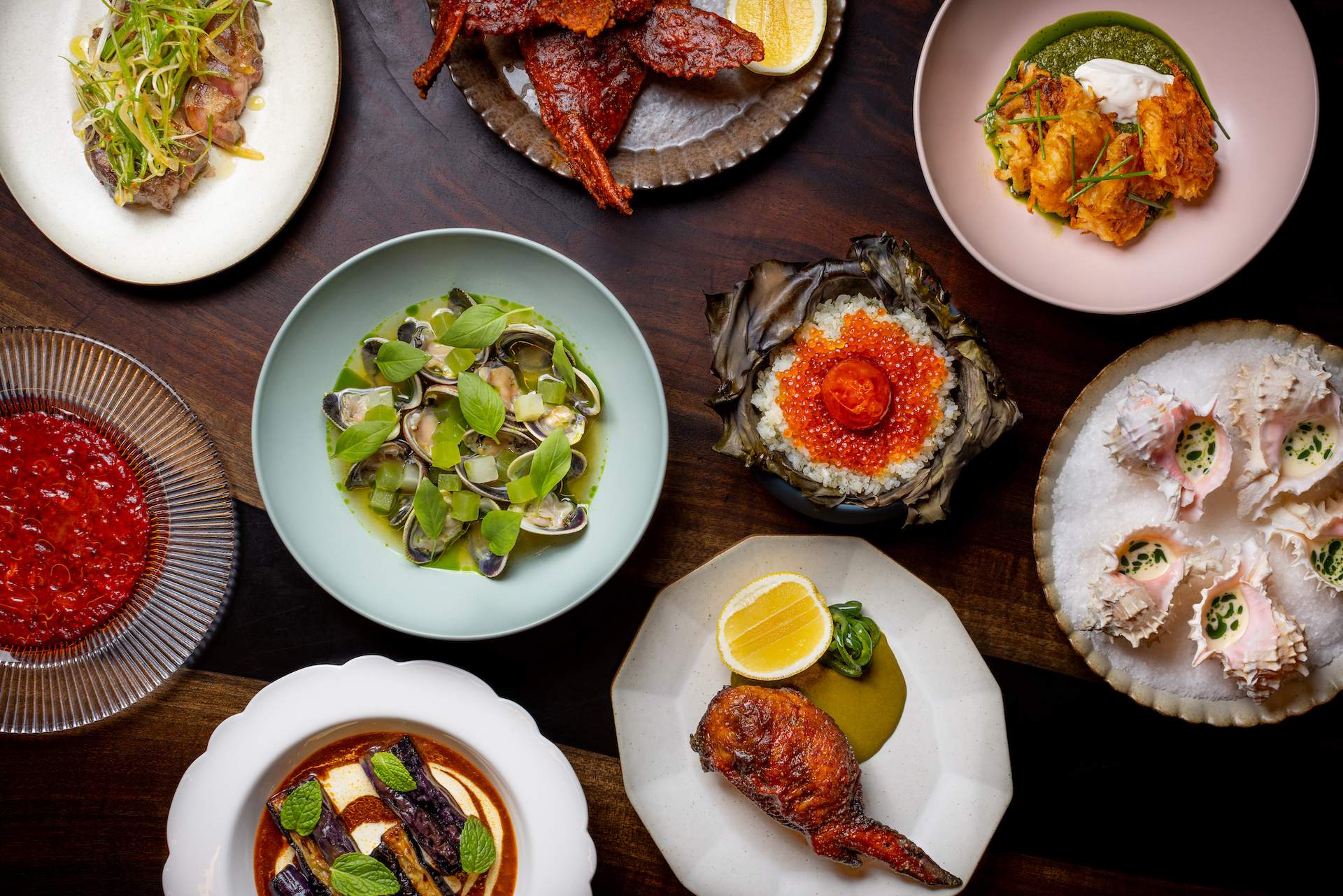 A series of dishes on a wooden table at the Los Angeles restaurant Angler.