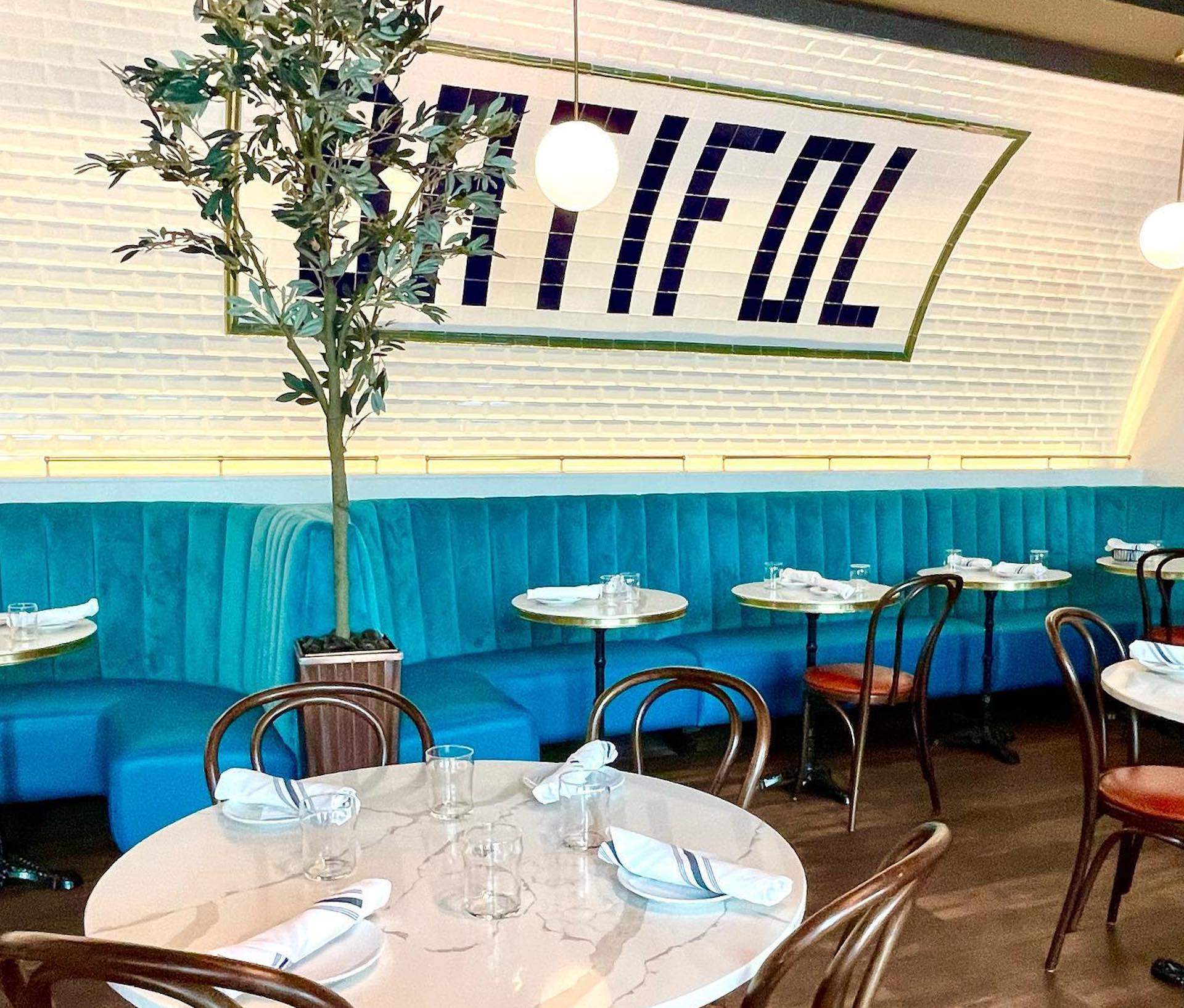 The interior of the French restaurant Batifol with subway tiles on the wall.