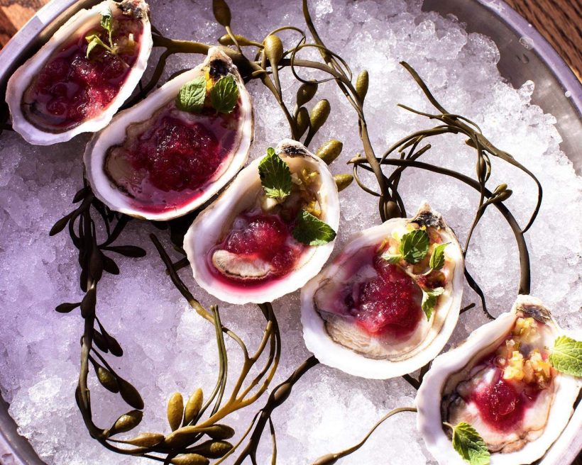 Five oysters placed in a line over ice at Banks Fish House in Boston