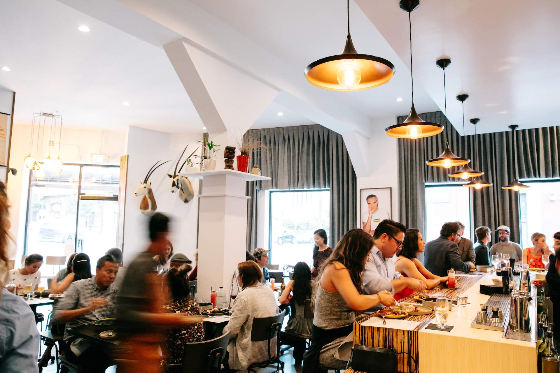 The interior of the LA restaurant Here's Looking at You, with a wooden counter and tall ceilings