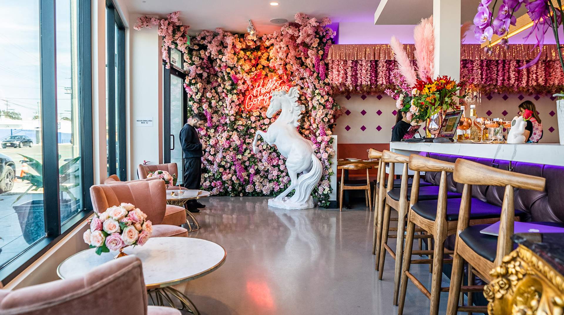 The interior of the restaurant Farmhouse Thai Kitchen in Los Angeles with a unicorn wall hanging in the background