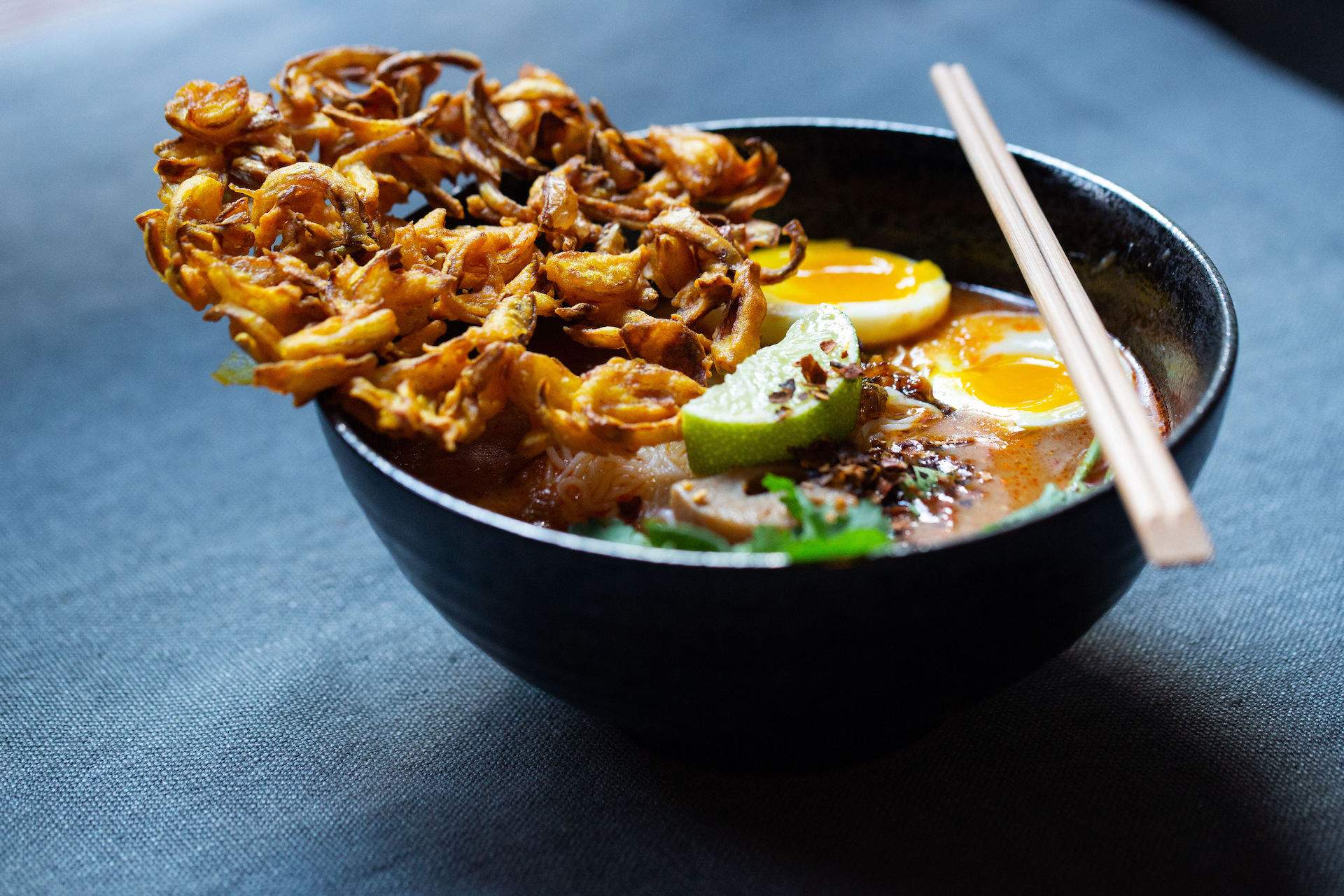 A soup with crispy onions and soft boiled eggs at NYC Burmese restaurant Rangoon.
