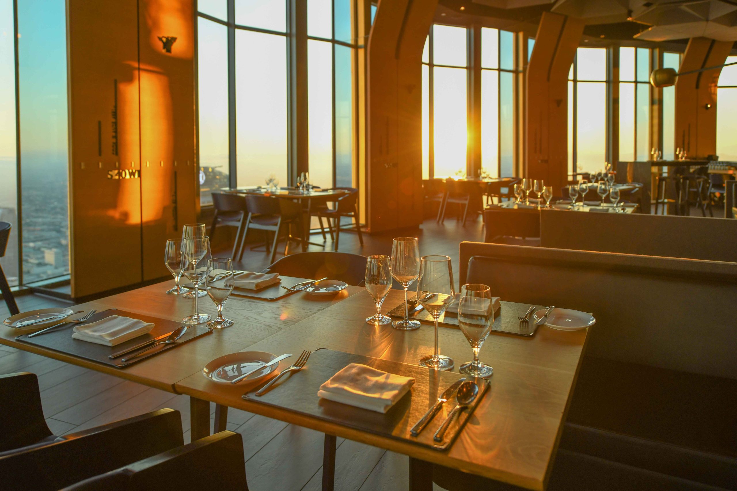 Sunlight streams through the floor-to-ceiling windows in the wood-clad dining room at 71Above in Los Angeles